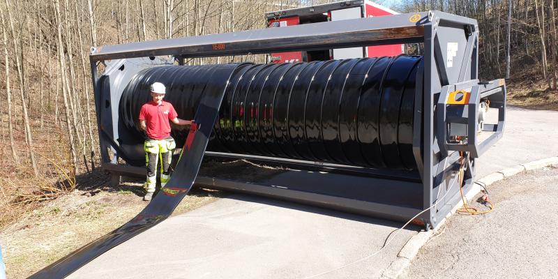 Bildet ble tatt under etablering av en bypass avløpsledning ved Fossumbekken i Oslo. Ved kveilen, på 5 meters bredde, er Dennis Stamnes. På kveilen er 1200 meter DN 300 Primus Line Overland. En elektromotor montert på siden av denne hjelper til med å dra ut og inn lineren.