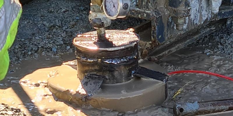 Bildet viser faststøping av borehullet, der betongen kommer opp til overflaten, noe som viser at støpen er ferdig.